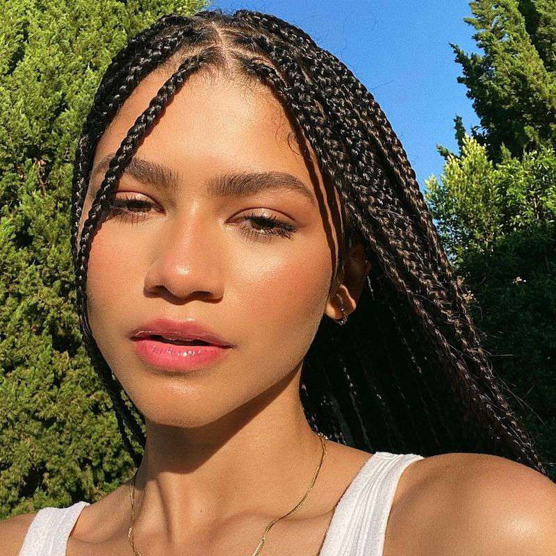 Zendaya wears bold eyebrows, dewy makeup, and box braids
