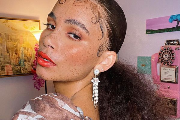 Close up of a woman with bold lipstick, a smooth pony tail, and laid baby hair