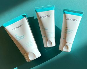 Three Proactiv products on a green background, with a hint of sunlight