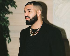 Drake wears a thick, full beard and short hairstyle