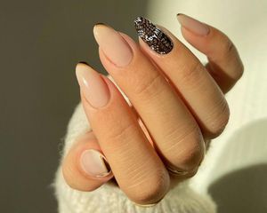 Manicure with neutral polish and Goyard-patterned accent nail