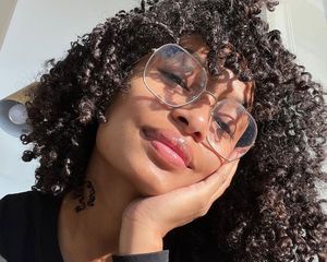 Yara Shahidi wears large wire glasses and her natural type 3C curly hair