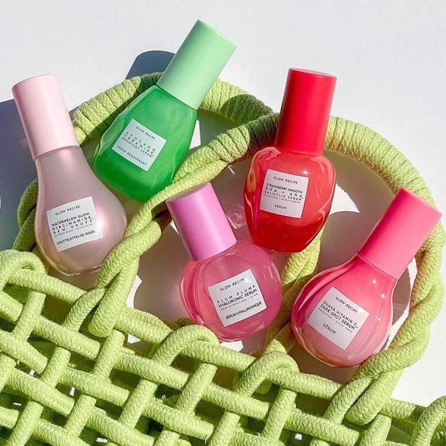 Glow Recipe skincare products with lime green woven bag on white background