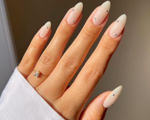Close up of a woman's long fingernails with subtle gems