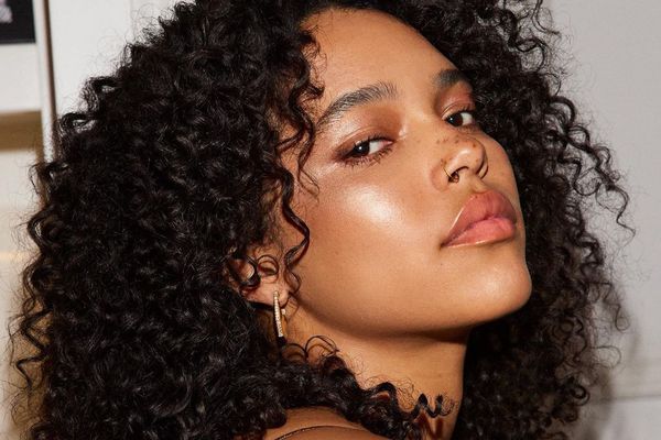 Woman with dewy, radiant makeup look and naturally curly hair