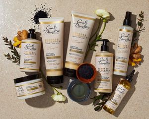 Assortment of Carol's Daughter Goddess Strength products with flowers and natural ingredients