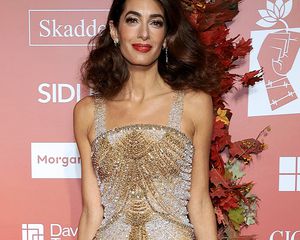 Amal Clooney in a red lip and gold gown