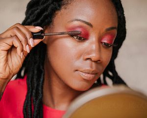 Woman applying red eye makeup