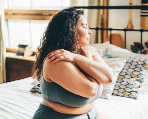 Curly haired young woman in blue top and shorts