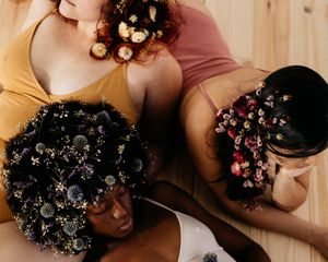 three women with floral hair pieces