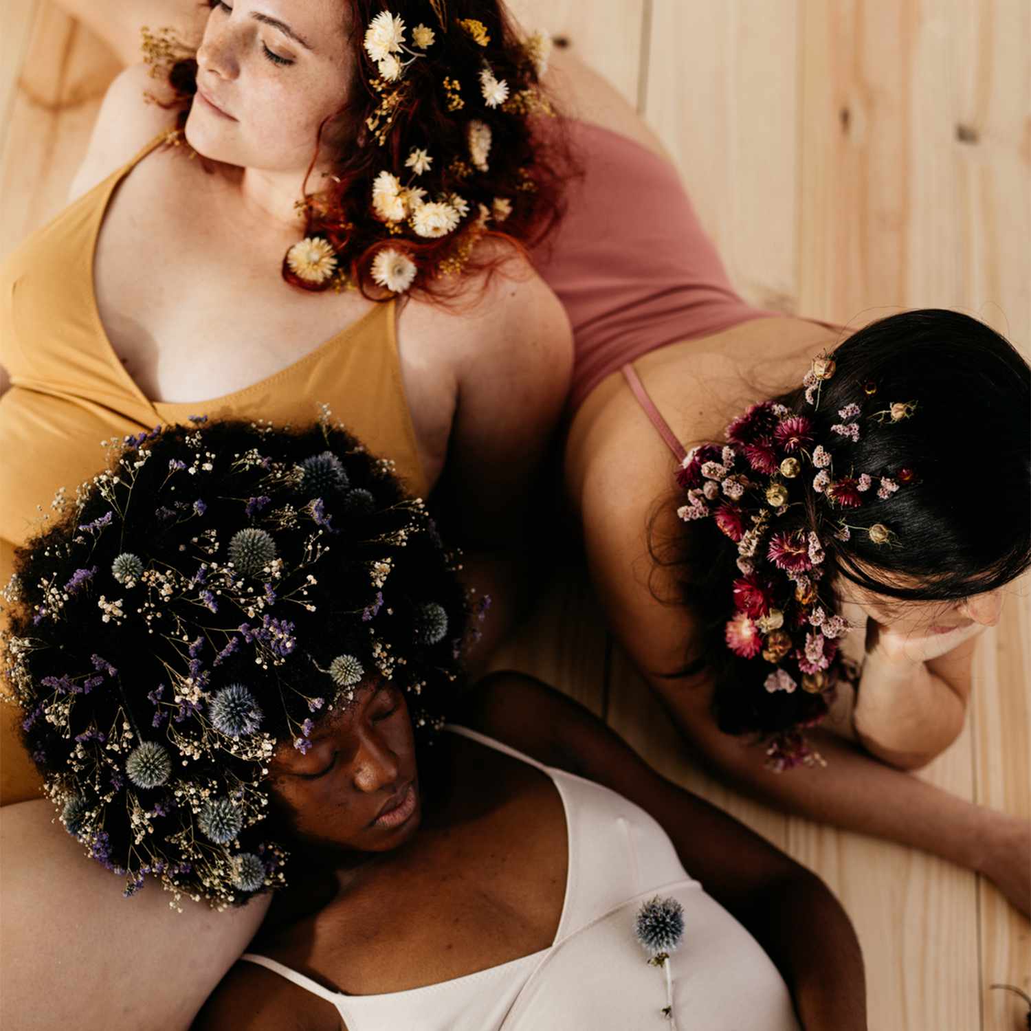 three women with floral hair pieces