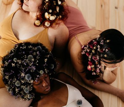three women with floral hair pieces