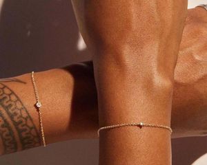 Model wearing permanent gold bracelets from Catbird
