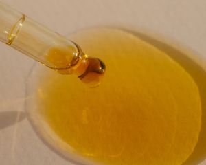 spilled skincare oil on tan background