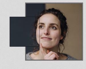 Woman with a dimple with her hand on her chin.