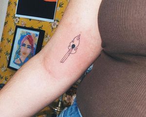 A lit match tattoo on an arm 
