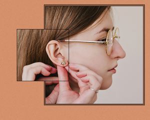 Woman putting on earrings.