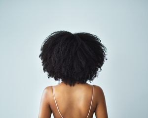 Black woman with kinky, curly natural hair and a smooth back