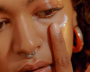 woman applying face moisturizer