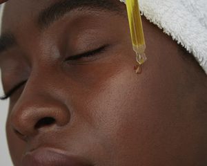 woman putting on face oil