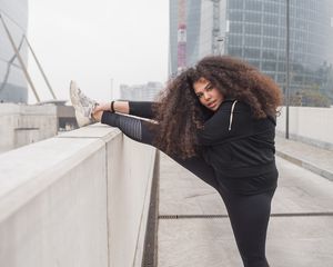Woman stretching on a bridge in fitness clothes