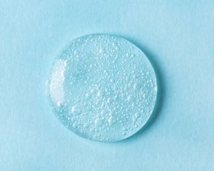 droplet of skincare product on blue background