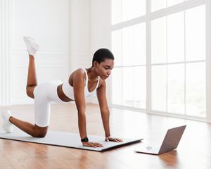 Woman does a donkey kick in a light, spacious room