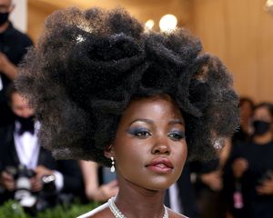 Lupita Nyong'o wears a voluminous, avant garde hairstyle and blue eye makeup