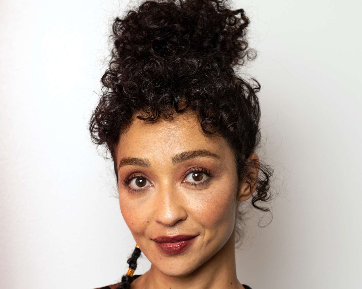 Ruth Negga wears a curly updo with baby bangs