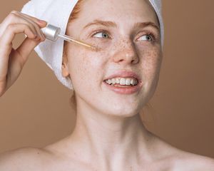 Woman applying a serum to her face