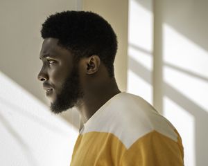 Man with well-groomed beard in sunny room