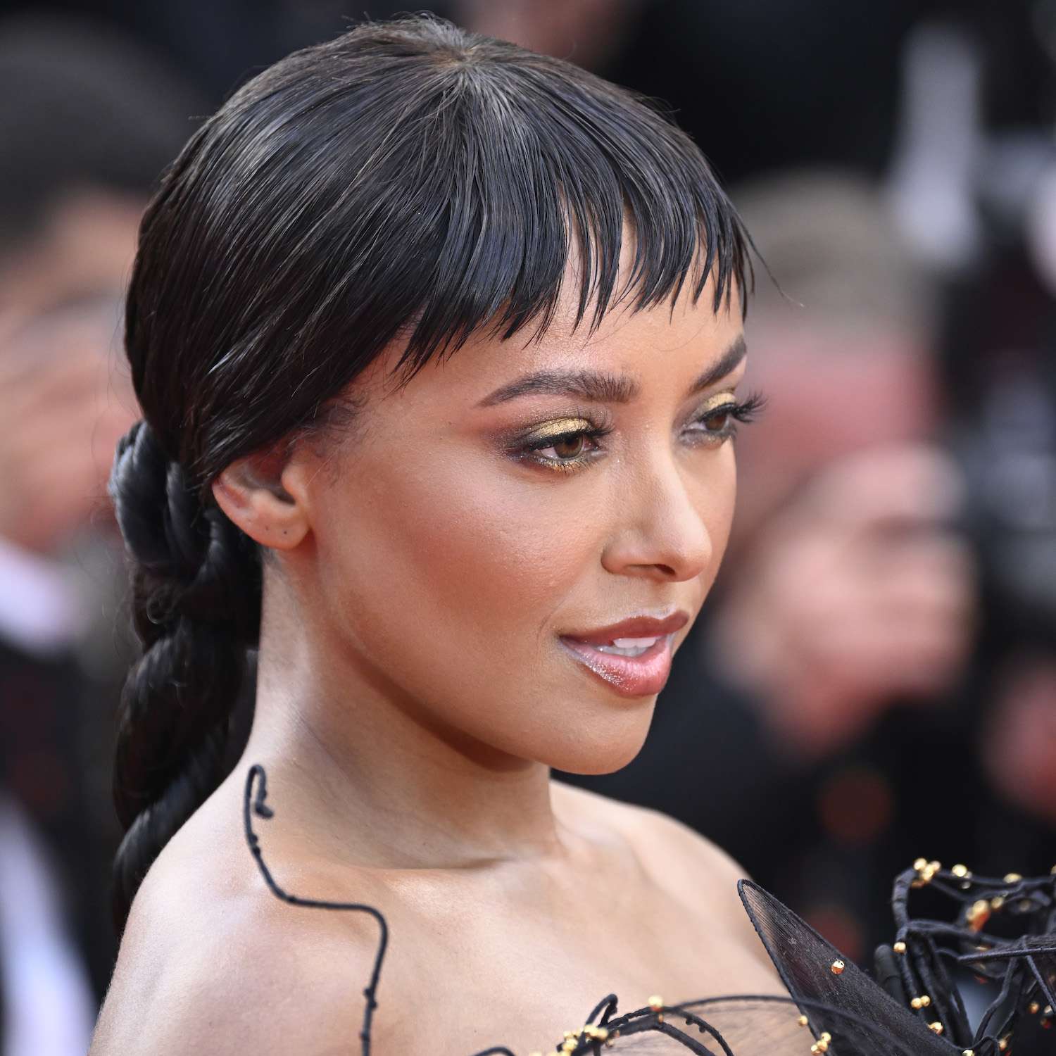 Kat Graham wears piece-y baby bangs with a long rope braid hairstyle