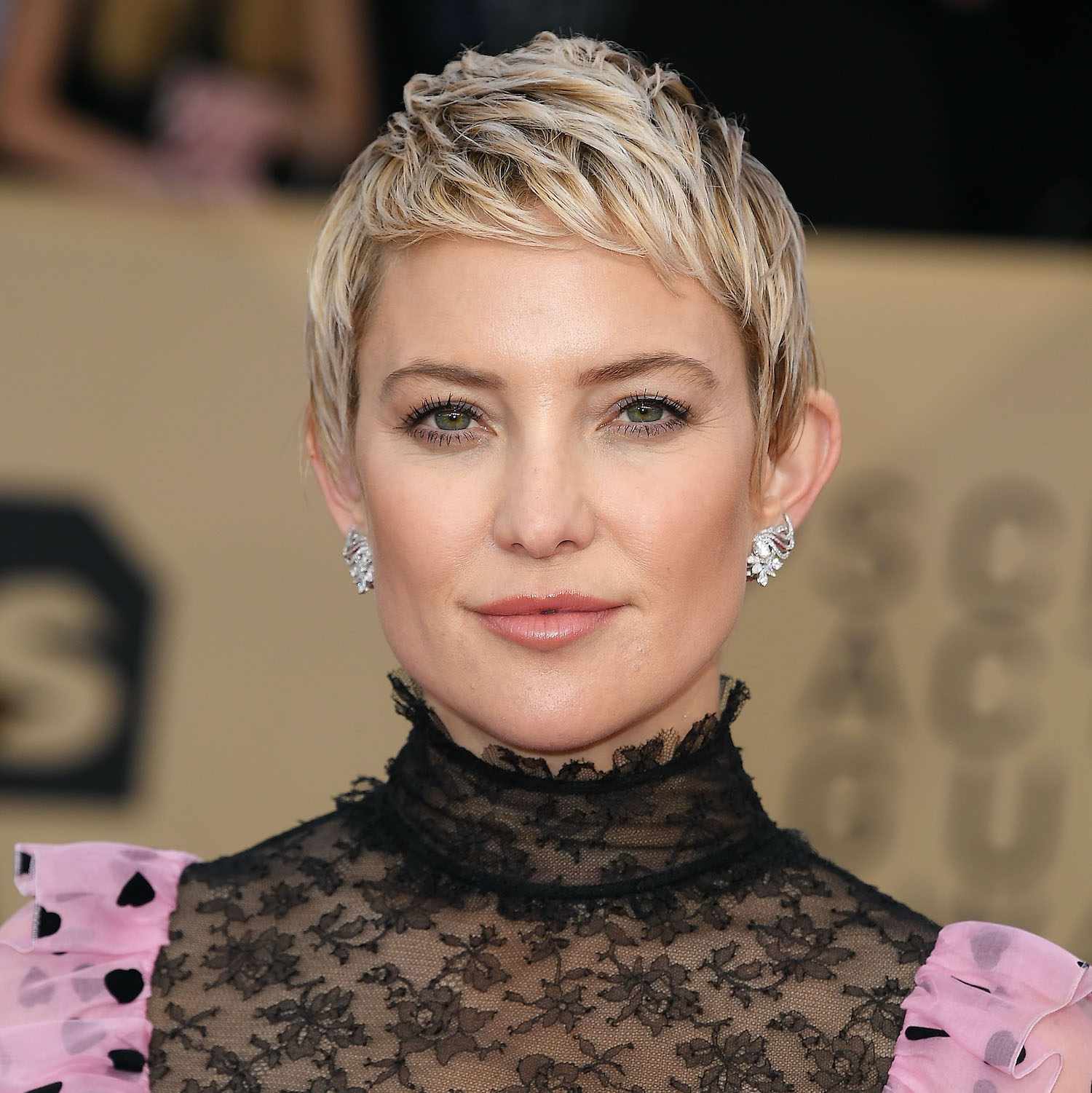Kate Hudson wears a blonde pixie cut with baby bangs