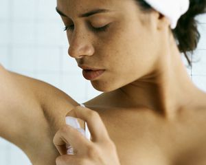 woman applying deodorant 