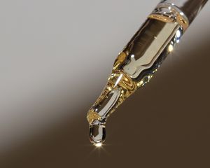 Oil coming out of the tip of a dropper.