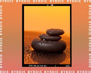 Three black pebbles piled on top of one another. 