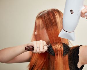 Woman blow dries her hair