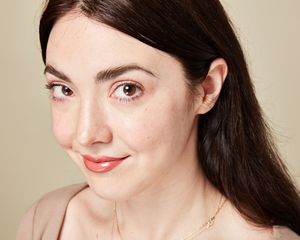 A woman with glossy, peach-y colored lips