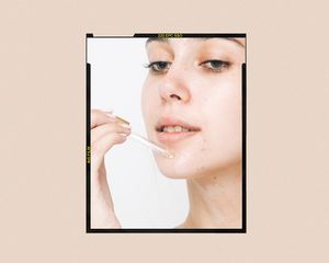 Woman applying a serum to her chin