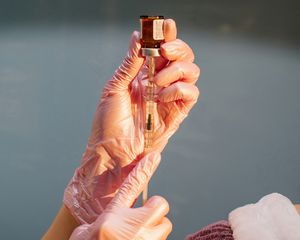 gloved hand holding injectible