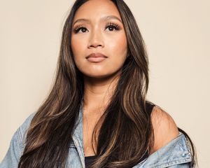 woman in jean jacket with long eyelashes