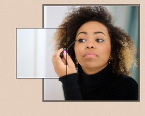 woman applying mascara to right eye