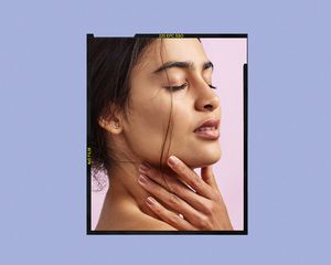 South Asian woman touches her face