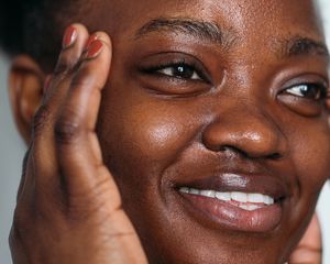 Smiling woman with her fingers at her temples
