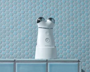 NuFace Trinity+ microcurrent tool on a blue background