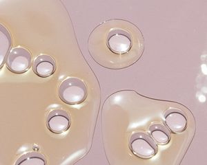 Drops of oil on a pink background