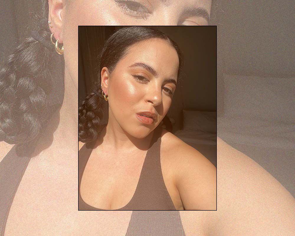 Star Donaldson wearing gold hoop earrings and a brown halter top.