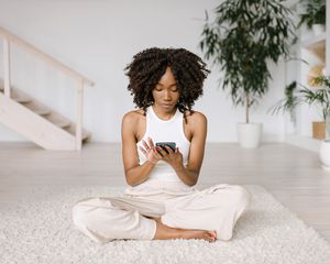 Woman using her phone about to meditate