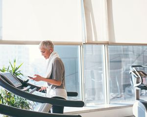 woman on a treadmill, looking at her phone