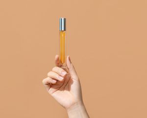 perfume oil in tube in hand